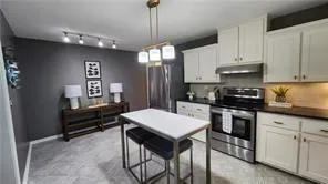 a kitchen that has a lot of cabinets a sink and dishwasher in it