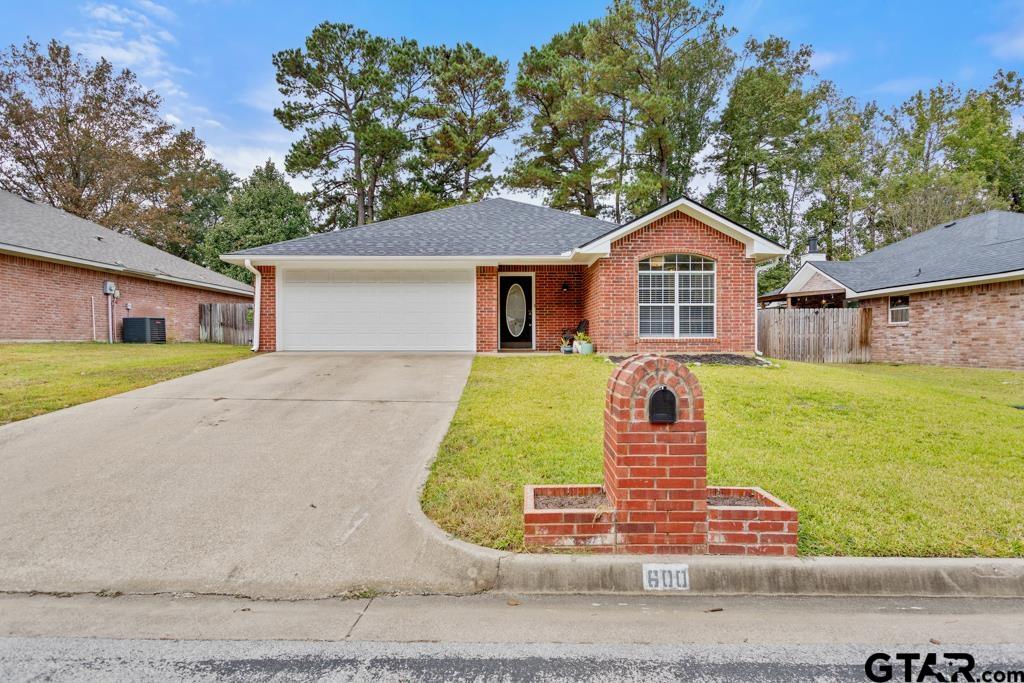 a front view of a house with a garden and yard