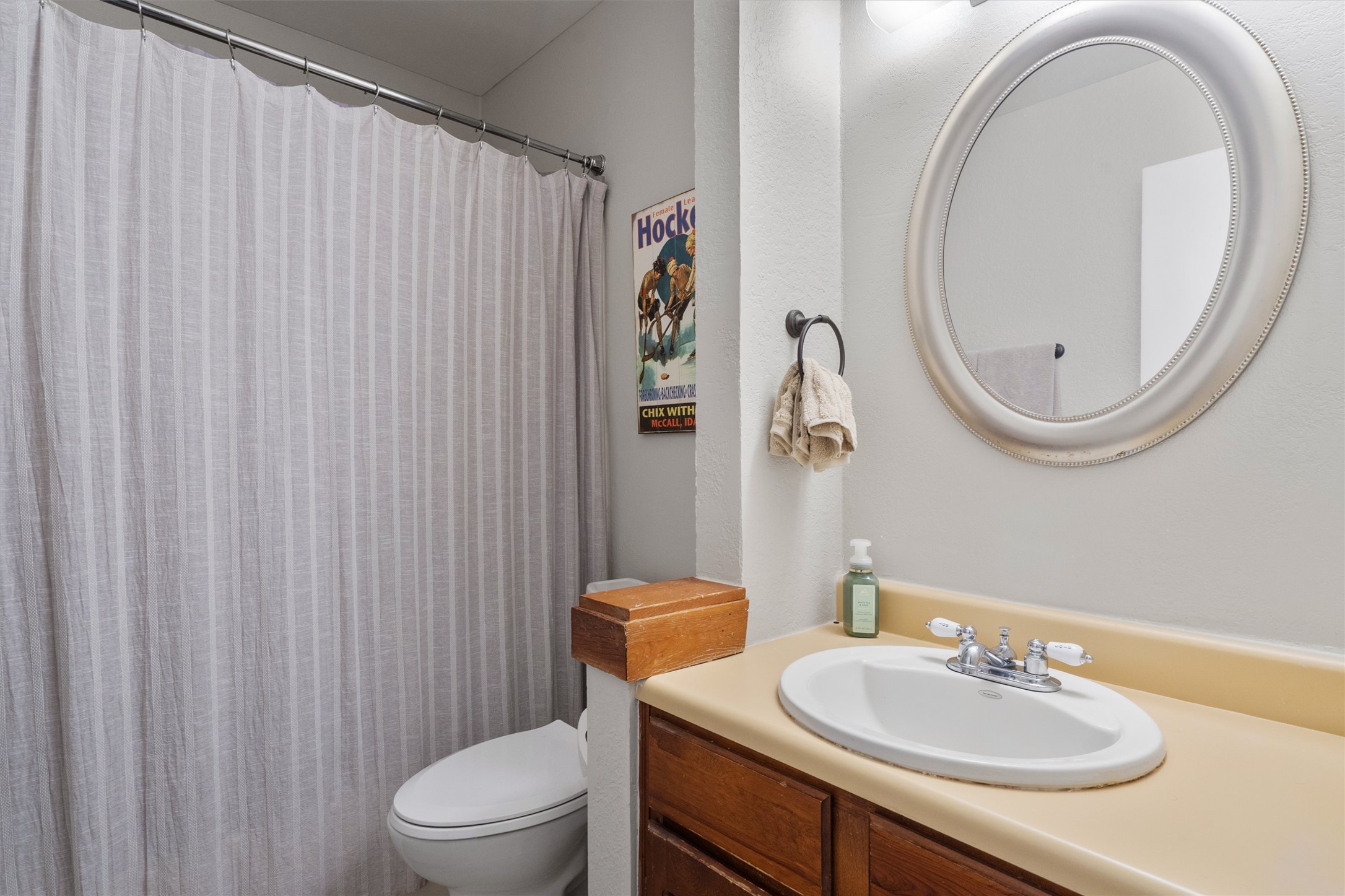 2414 Jones Road Austin, TX 78745 - Photo 15 of 26 A well-appointed bath features a bright white toilet, a shower with a privacy curtain, and a vanity with a clean white sink.