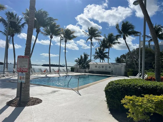 a row of palm trees in front of a house