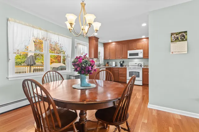 a view of a dining room with furniture a chandelier and wooden floor