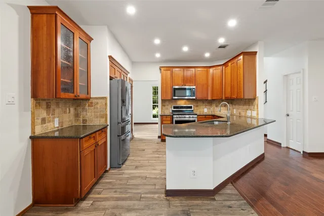 a kitchen with stainless steel appliances granite countertop a stove a sink and a refrigerator