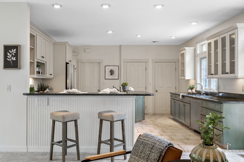 209 Maple Street Danvers, MA 01923 - Photo 14 of 42 a kitchen with stainless steel appliances granite countertop a table chairs sink and cabinets