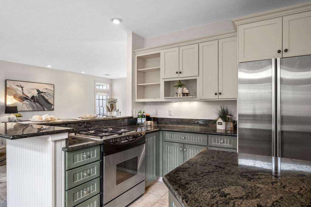 209 Maple Street Danvers, MA 01923 - Photo 21 of 42 a kitchen with stainless steel appliances granite countertop a sink stove and refrigerator
