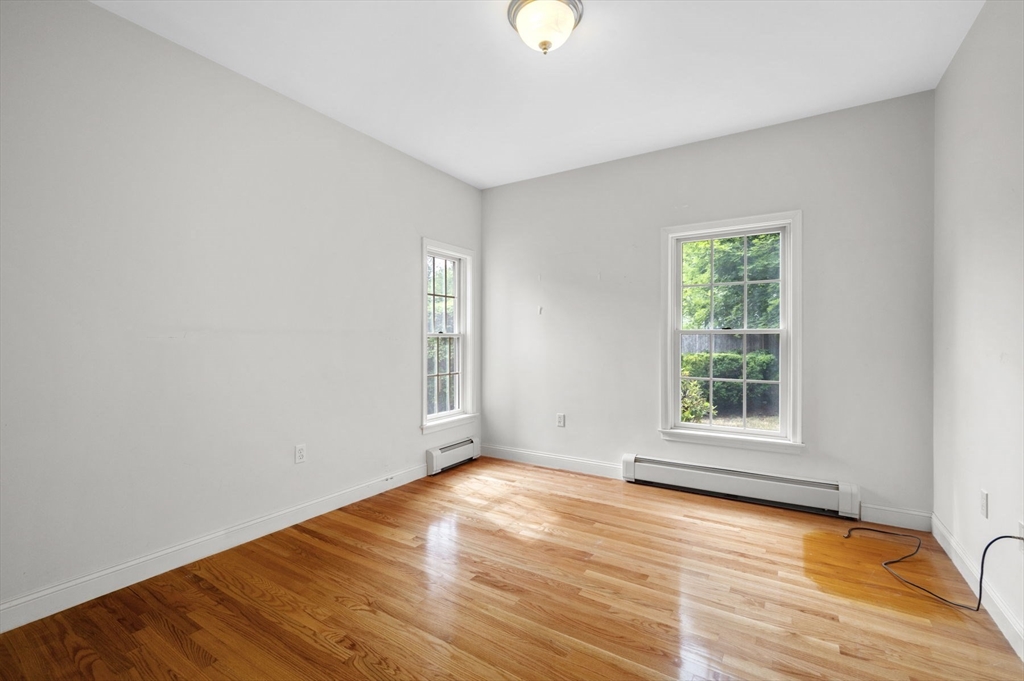 209 Maple Street Danvers, MA 01923 - Photo 29 of 42 an empty room with wooden floor and windows