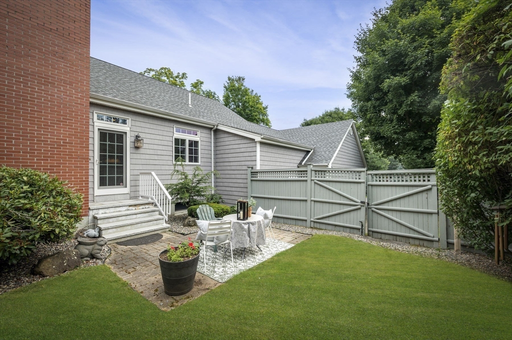 209 Maple Street Danvers, MA 01923 - Photo 39 of 42 a view of a patio with table and chairs potted plants with wooden fence