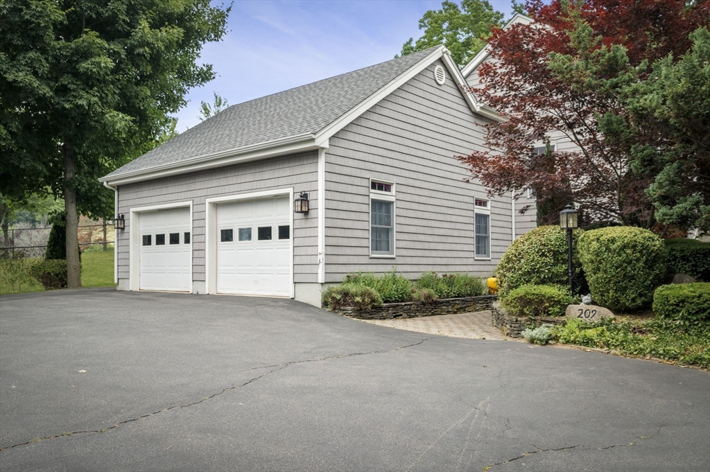 209 Maple Street Danvers, MA 01923 - Photo 4 of 42 a view of white house with a yard and potted plants