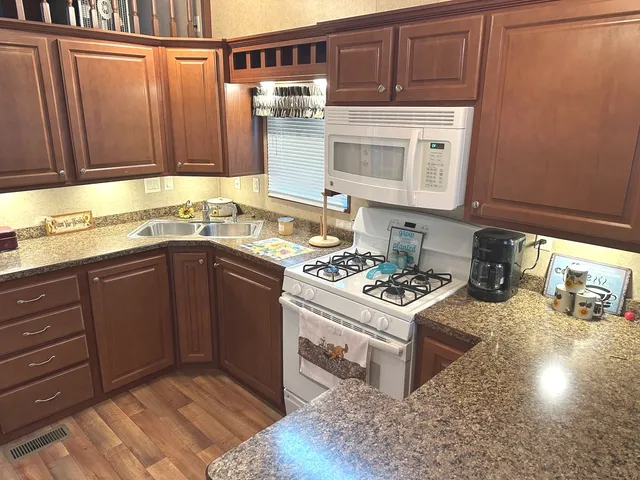 a kitchen with stainless steel appliances granite countertop a stove a sink and a microwave