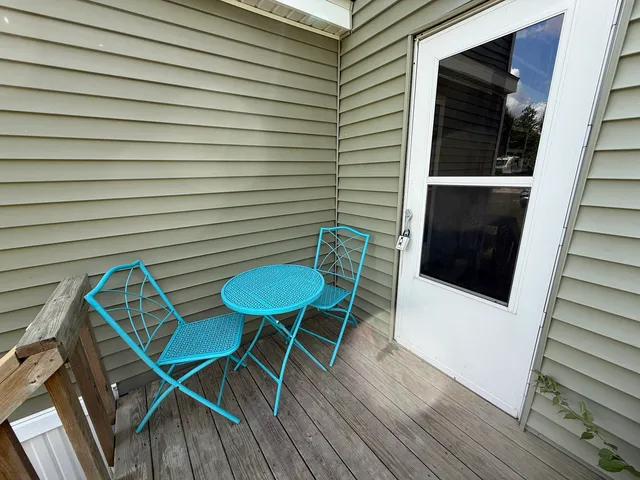 a view of a balcony with chairs and wooden floor