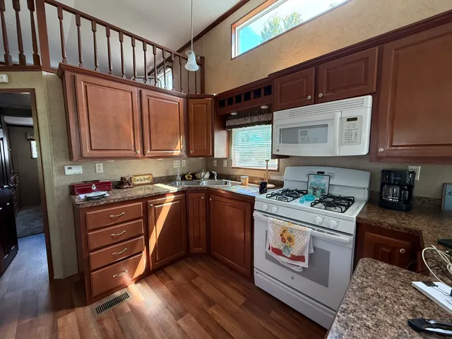 a kitchen with stainless steel appliances granite countertop a stove a sink and a microwave