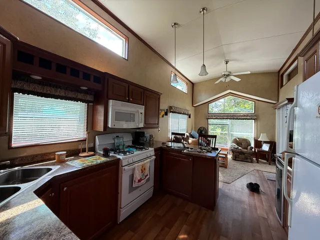 a kitchen with a sink appliances cabinets and a large window