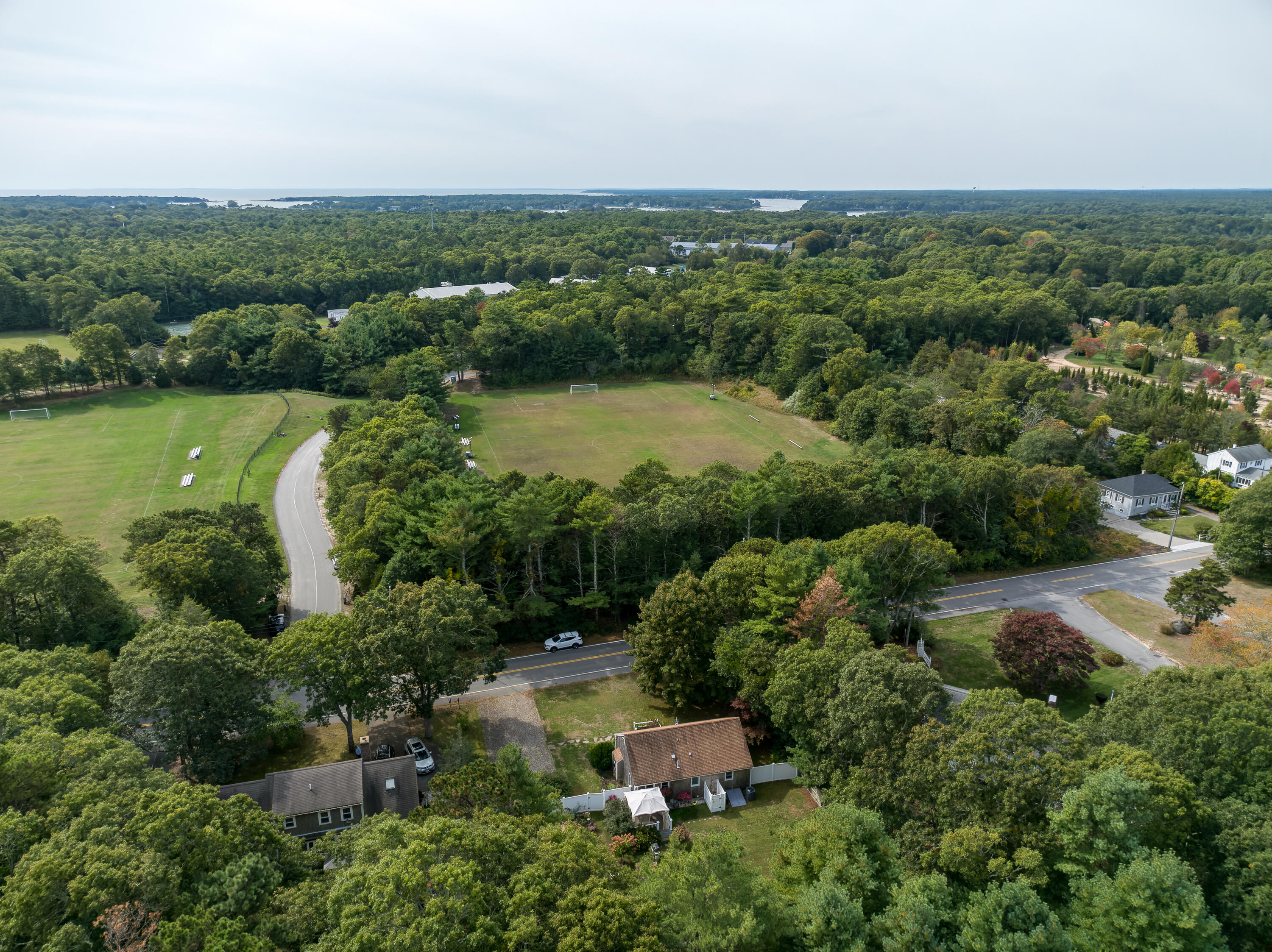 268 Bumps River Road Osterville, MA 02655 - Photo 29 of 33 an aerial view of green landscape with trees houses and lake view