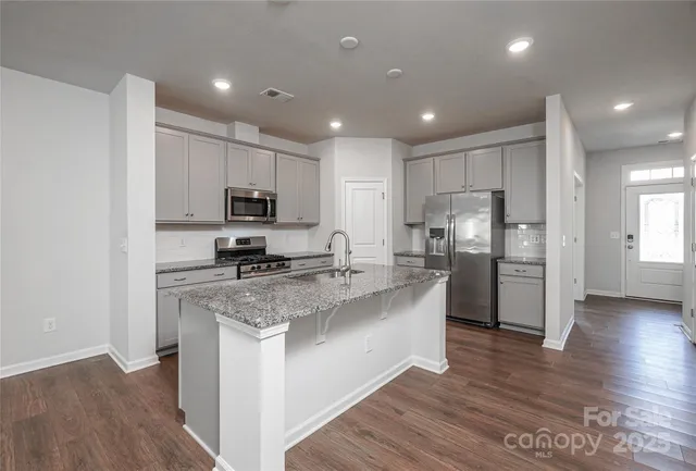 a kitchen with granite countertop a sink stainless steel appliances and cabinets