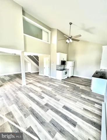 a view of a bedroom with a bed and a ceiling fan