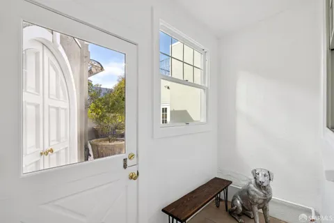 a view of a hallway with wooden floor and a window