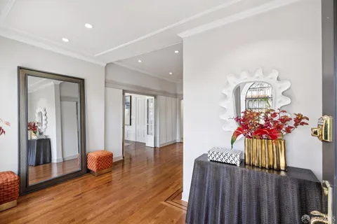 a view of a hallway with wooden floor and windows
