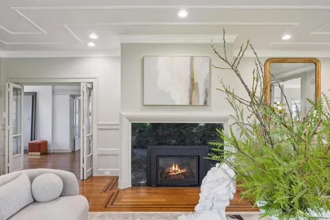 a living room with furniture a fireplace and a chandelier