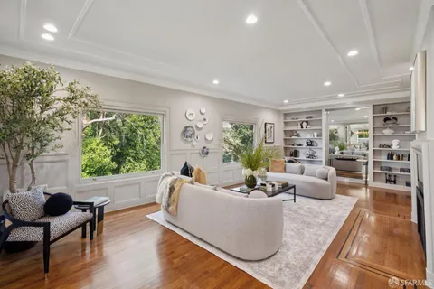 a large kitchen with stainless steel appliances a refrigerator a sink dishwasher and white cabinets with wooden floor