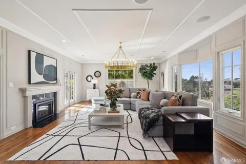 a very nice looking kitchen with granite countertop a stove a sink dishwasher a dining table and chairs with wooden floor