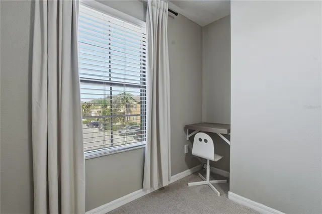 a view of a hallway with a chair and a window