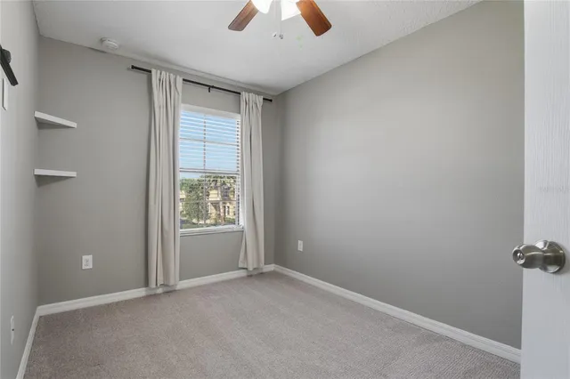 an empty room with closet and windows