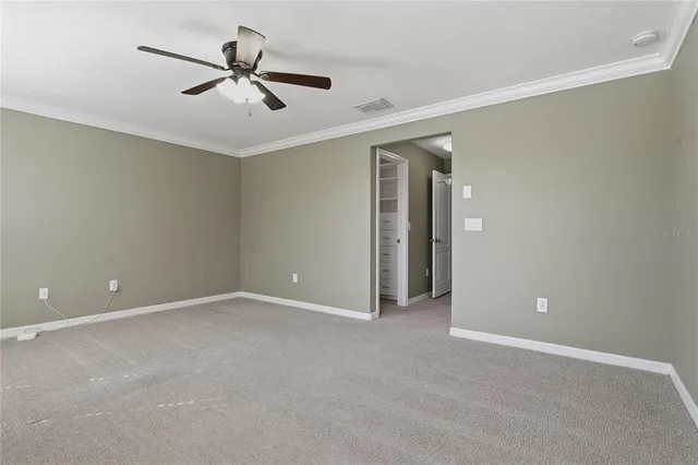 an empty room with closet and a chandelier fan