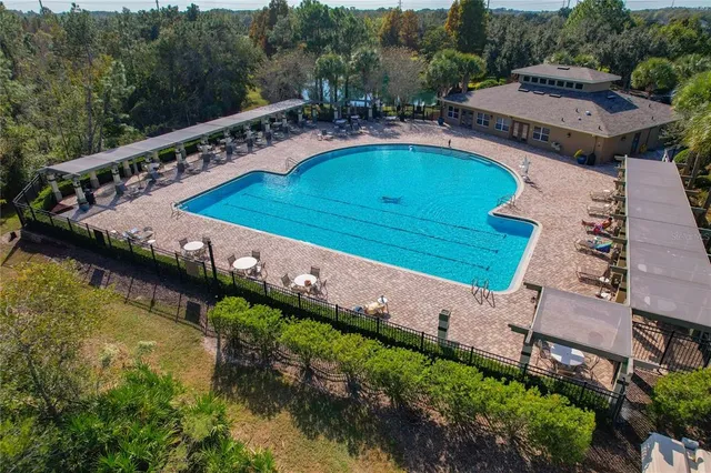 an aerial view of a house with a swimming pool patio and outdoor seating