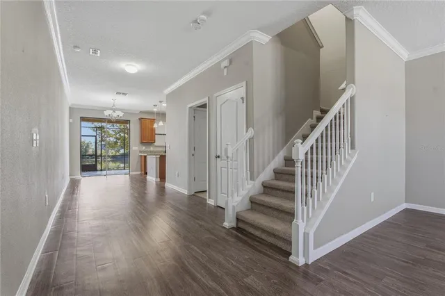 a view of a hallway with wooden floor and windows