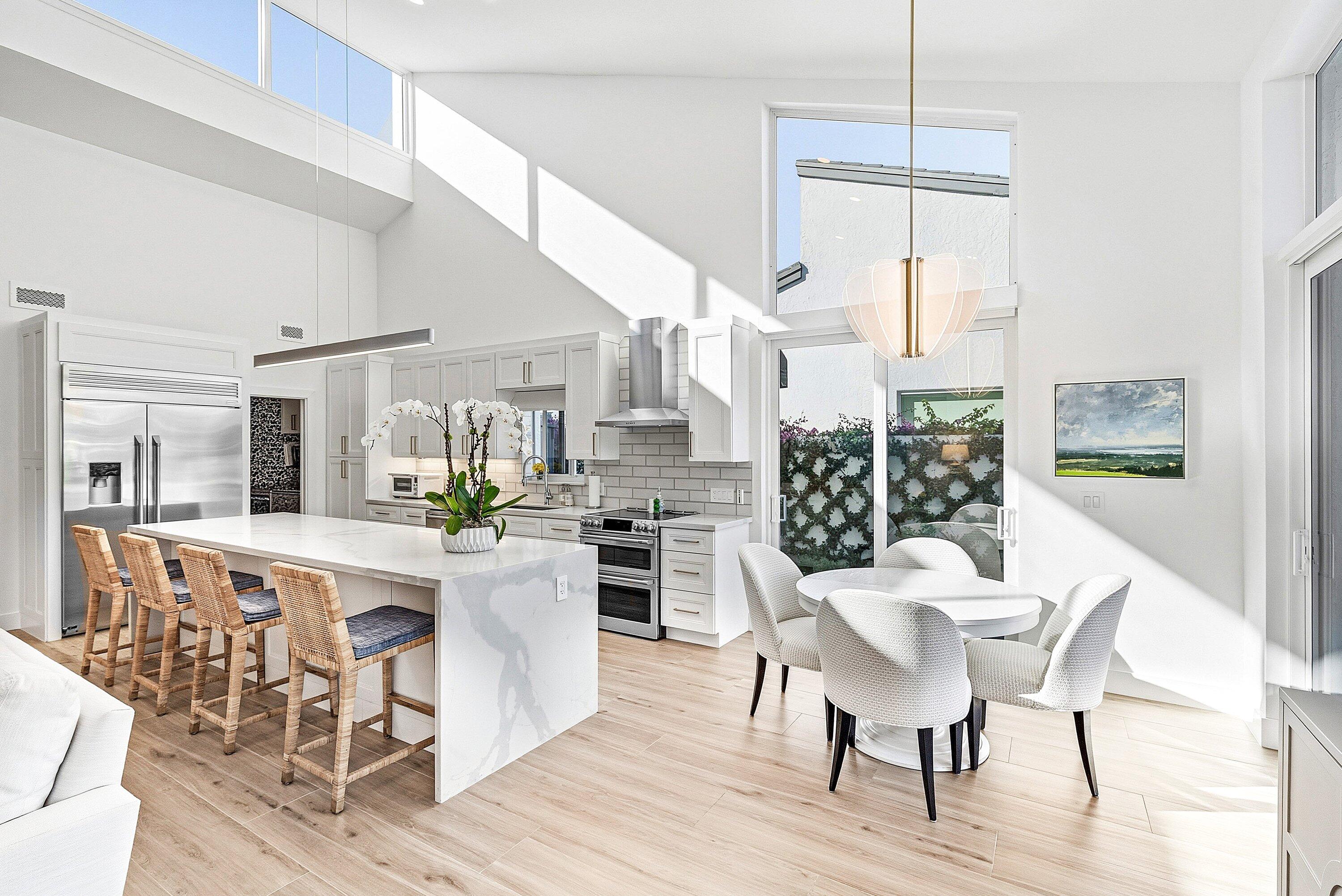 6110 North Ocean Boulevard, Unit 32 Ocean Ridge, FL 33435 - Photo 11 of 39 a kitchen with stainless steel appliances kitchen island granite countertop a dining table chairs and white cabinets