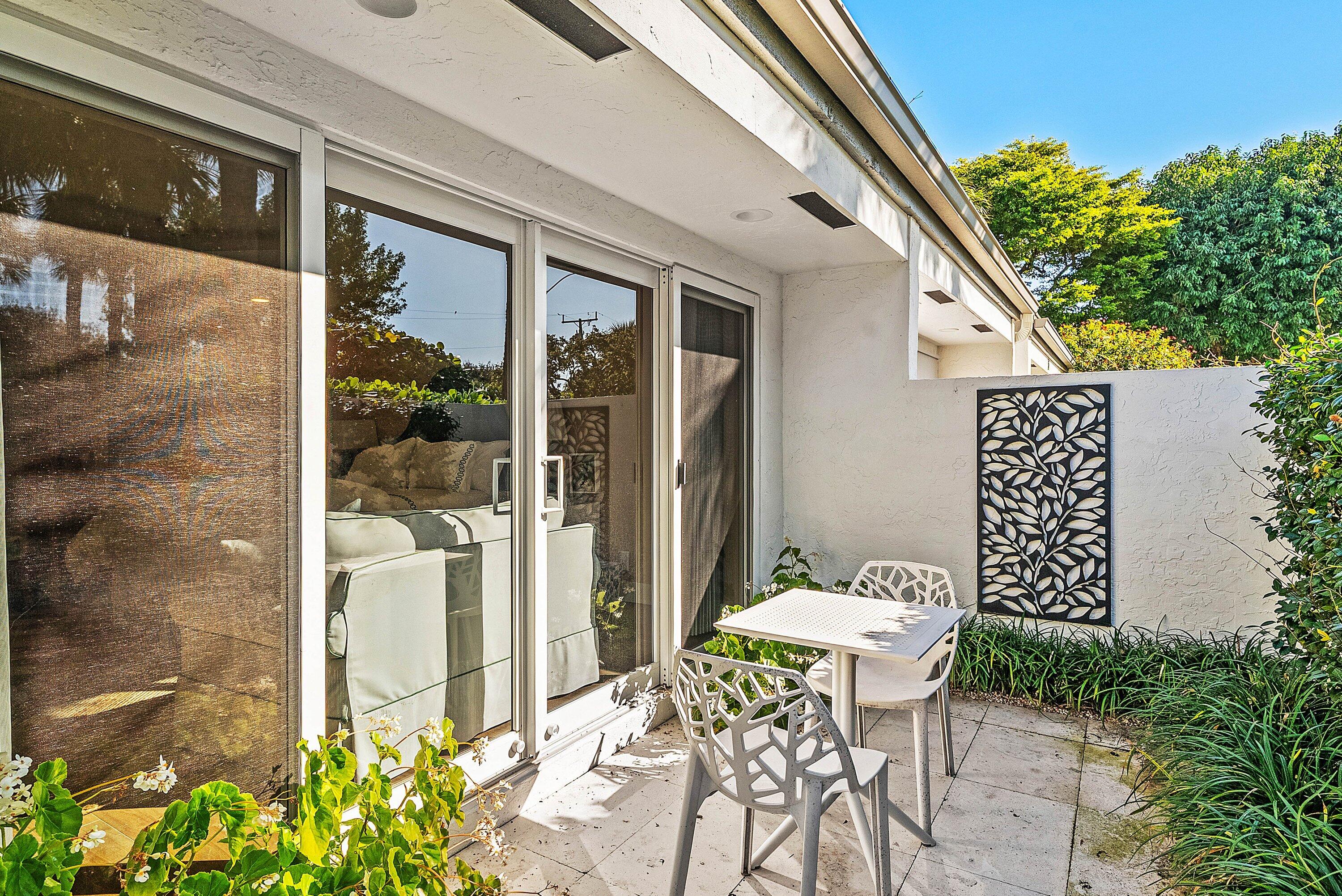 6110 North Ocean Boulevard, Unit 32 Ocean Ridge, FL 33435 - Photo 29 of 39 a balcony with table and chairs and potted plants