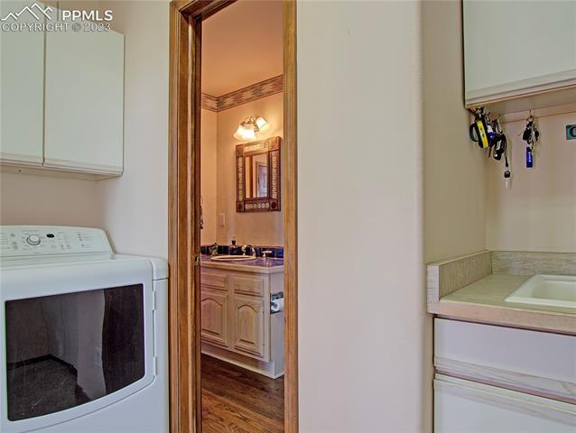 1165 Bowstring Road Monument, CO 80132 - Photo 12 of 27 Laundry room complete with washer, dryer, and sink and provides access to main level half bathroom and to 3 car garage.