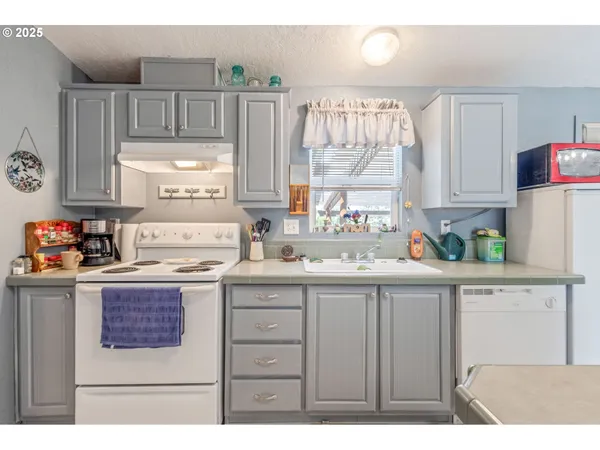 a kitchen with kitchen island granite countertop a sink window and cabinets