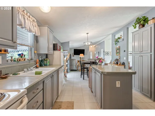 a kitchen with kitchen island a sink stove and refrigerator