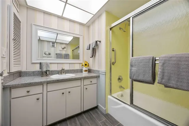 a bathroom with a granite countertop sink vanity granite tub and shower