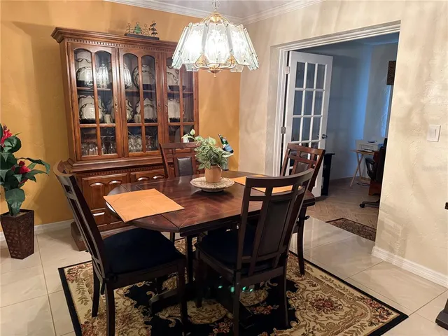 a dining room with furniture a chandelier and window