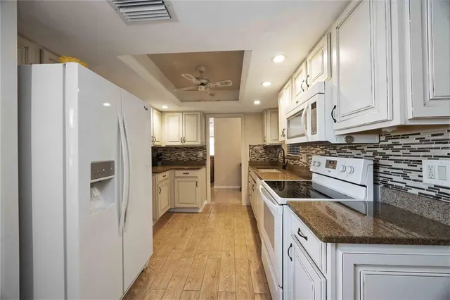 a kitchen with a refrigerator sink and cabinets