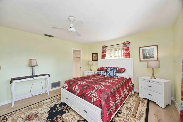 a bedroom with a bed and wooden floor