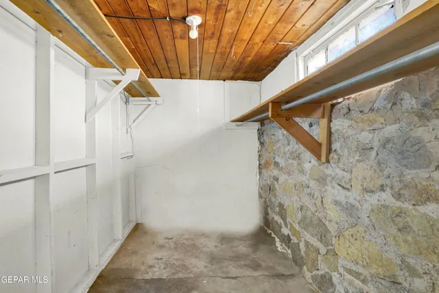 a view of an empty room with wooden floor and a ceiling fan