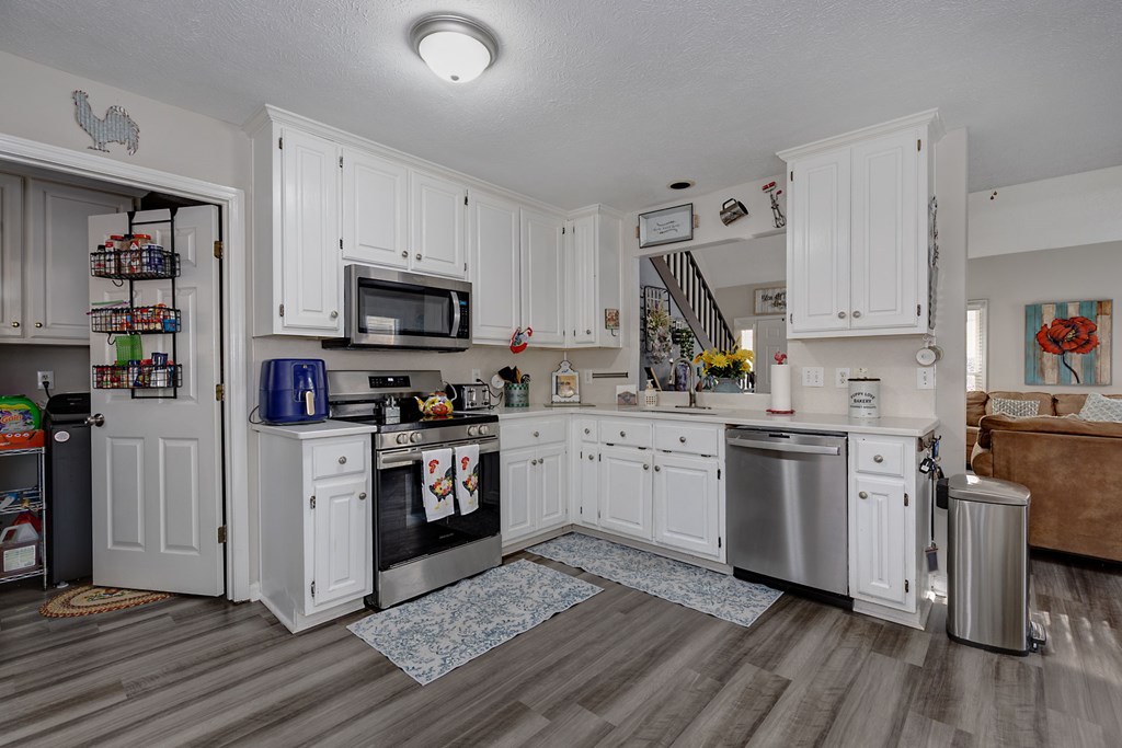1236 Martin Road Hamilton, GA 31811 - Photo 7 of 33 a kitchen with granite countertop a refrigerator stove and wooden floor