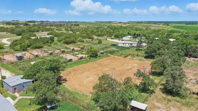 an aerial view of residential houses with outdoor space and trees