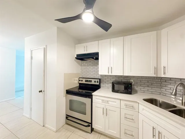 a kitchen with white cabinets and white appliances