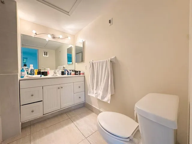 a spacious bathroom with a toilet sink and mirror