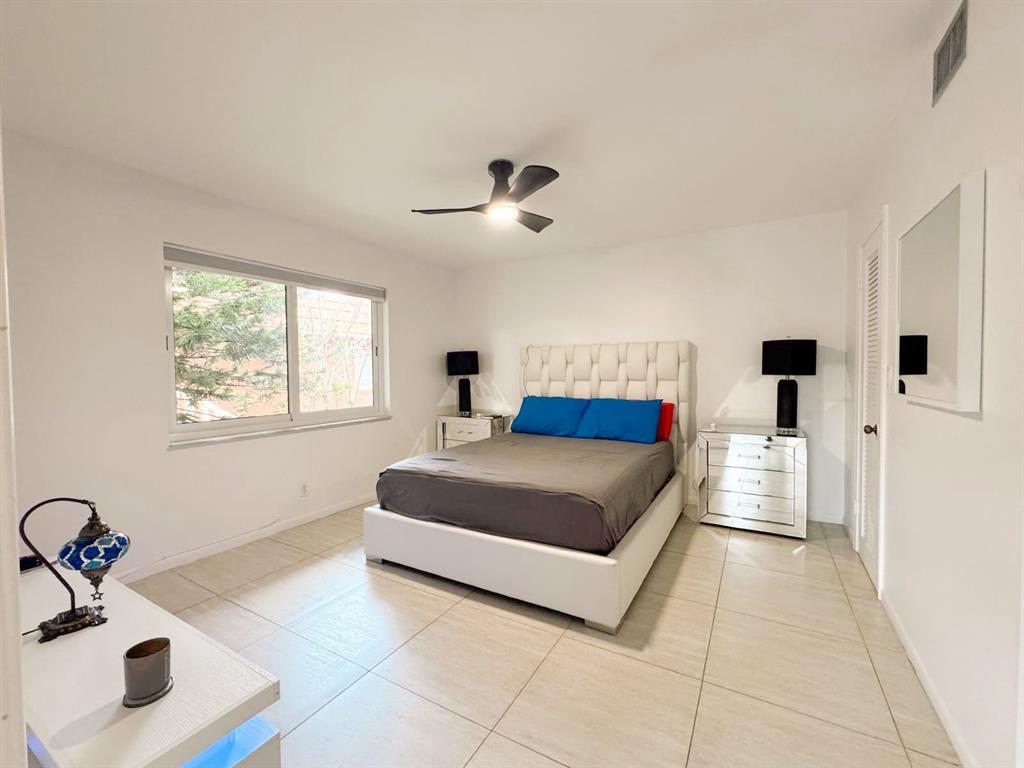 136 Northeast 19th Court, Unit 216F Wilton Manors, FL 33305 - Photo 20 of 26 a living room with a bed furniture and next to a window