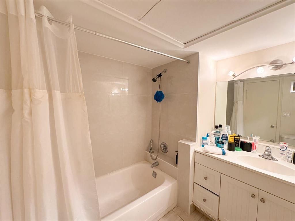 136 Northeast 19th Court, Unit 216F Wilton Manors, FL 33305 - Photo 22 of 26 a bathroom with a bathtub a sink and a shower