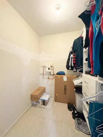 a view of walk in closet with clothes and shoes