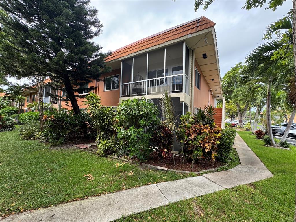 136 Northeast 19th Court, Unit 216F Wilton Manors, FL 33305 - Photo 25 of 26 front view of house with a yard