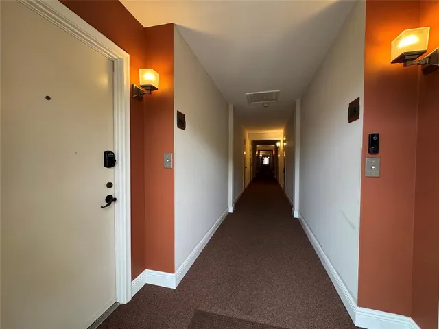 a view of a hallway with wooden floor and closet