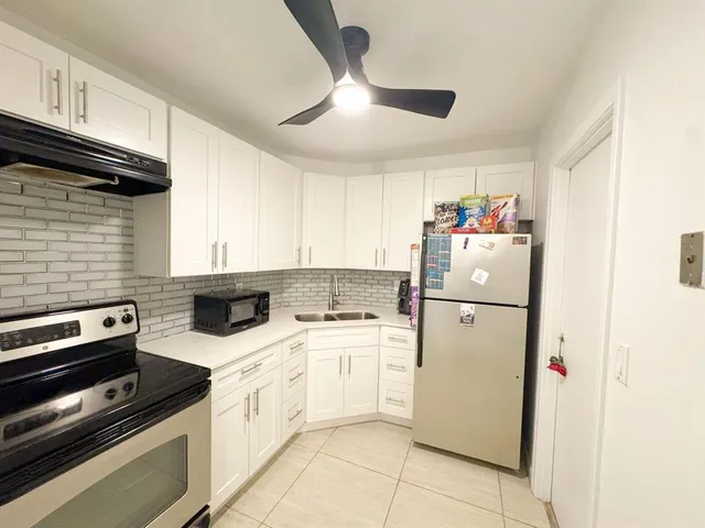 a kitchen with a white stove top oven and cabinets