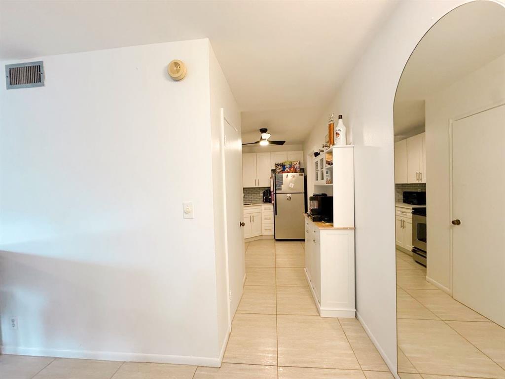 136 Northeast 19th Court, Unit 216F Wilton Manors, FL 33305 - Photo 6 of 26 a view of a kitchen with a refrigerator and a stove top oven