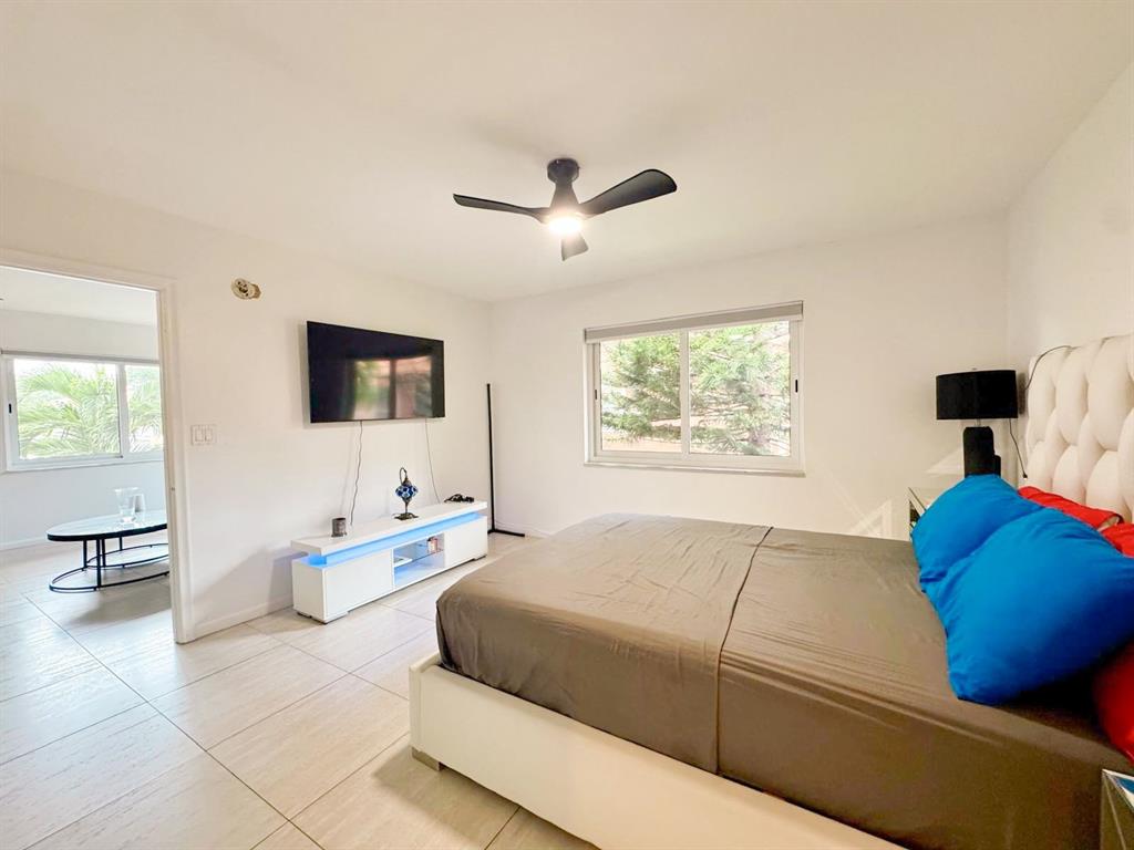 136 Northeast 19th Court, Unit 216F Wilton Manors, FL 33305 - Photo 7 of 26 a living room with furniture and a flat screen tv